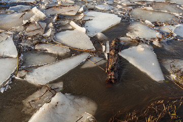 Close up view of ice and wood drift on the frozen river. Melting ice. Flooded road. Concept of spring floods