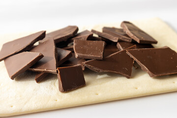 割った板チョコとパイ生地。チョコレートパイ作りをするイメージ