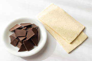 割った板チョコとパイ生地。チョコレートパイ作りをするイメージ