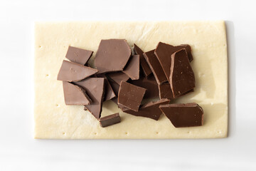 割った板チョコとパイ生地。チョコレートパイ作りをするイメージ