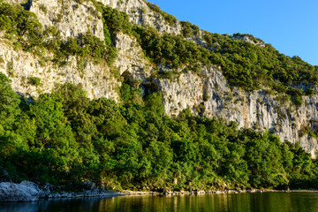 Fototapeta na wymiar The green banks of the Pont dArc in the Gorges de lArdeche in Europe, France, Ardeche, in summer, on a sunny day.