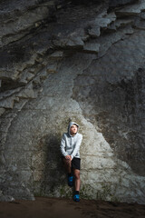 Fototapeta na wymiar Thoughtful hispanic active teenager against cliff wall