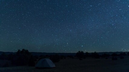 A night-to-day time-lapse of a tent under a star-filled night sky in the Grand Staircase-Escalante National Monument a few miles south of the town of Escalante, Utah. 
