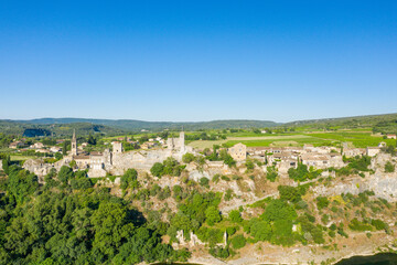 Fototapeta na wymiar The panoramic view of the town of Aigueze and its green countryside in Europe, France, Ardeche, in summer, on a sunny day.