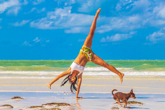 Sexy pretty woman does cartwheel Holbox island beach sandbank Mexico.