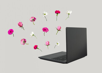 Workspace with black laptop and various spring flowers. Minimal spring vibe concept. Work from home. Blog, website or social media concept. Valentines day or 8 March card.