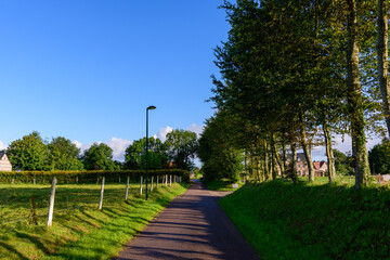 Obraz premium a street in the middle of the traditional French village of Saint Sylvain in Europe, France, Normandy, towards Veules les Roses, in summer, on a sunny day.