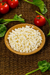 Feta Crumbled Cheese with Spinach and Tomatoes Background. Selective focus.