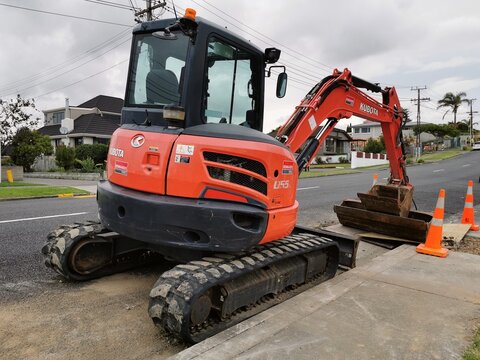 View of Kubota U55 tight tail swing compact excavator on side of road