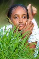 african american teenage girl lying on grass