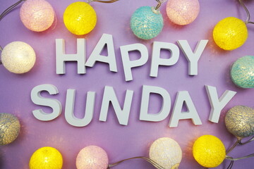Happy Sunday alphabet letters with LED cotton balls on purple background