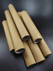 Photo of stack of brown cardboard rolls isolated on black background, Not Focus