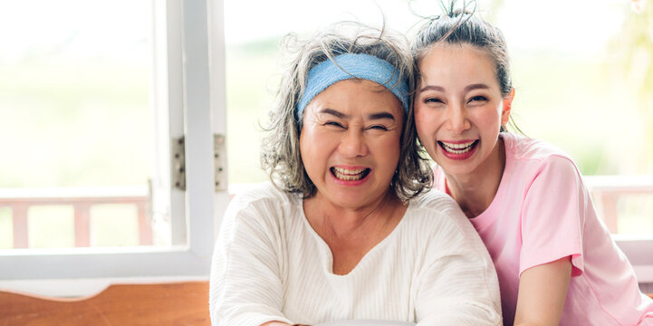 Portrait of enjoy happy love asian family senior mature mother and young daughter smiling laughing embracing and having fun hug together in moments good time at home