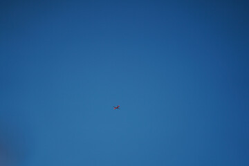 red plane in the air. photo with blue background.