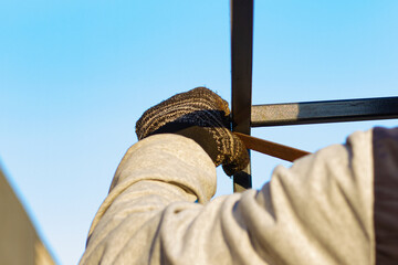 A man deburring a metal frame with a file. Hands of a working man with a file at work close-up.