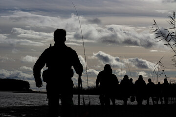 Silhouette of walking fishermen. Silhouettes of fishermen walking on the banks of the river national park.