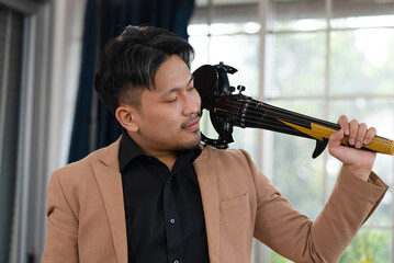 portrait of asian violinist holding electric violin