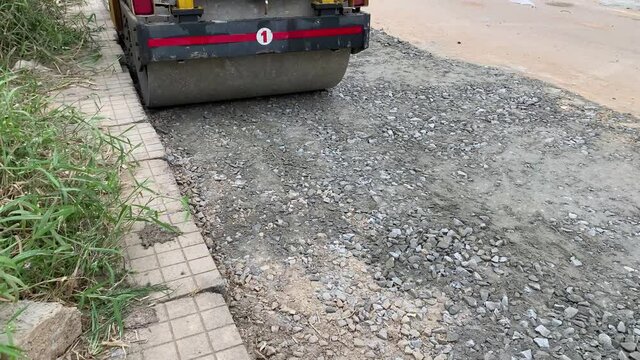 Road roller is compressing stone concrete mixture for new road construction 