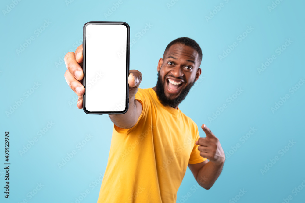 Poster Mobile app advertisement. Excited black man pointing at smartphone with empty screen, mockup. Space for ad or website