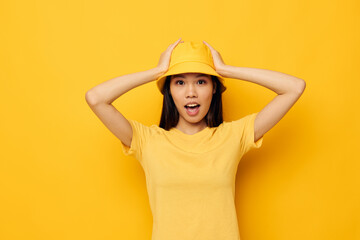 woman with Asian appearance in a yellow t-shirt and hat posing emotions isolated background unaltered