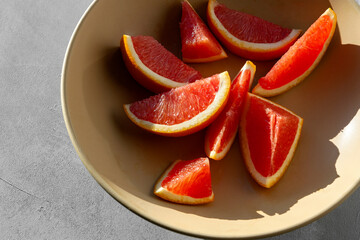 Naklejka na ściany i meble Red orange cut in slices on the plate