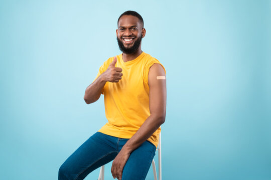 Covid-19 Vaccination. Smiling Black Man Showing Arm With Band Aid After Shot Of Coronavirus Vaccine, Showing Thumb Up