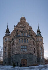 Apse and gable of old gothic museum stone house with towers a sunny and snowy winter day in Stockholm