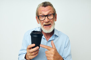 Portrait elderly man with a black glass in his hands a drink isolated background