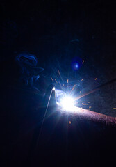 Welding of metal structures. Welding flame with sparks.