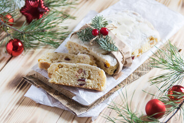 Obraz na płótnie Canvas Christmass stollen cake with nuts, raisins and dried fruit on cutting board on wooden background, selective focus