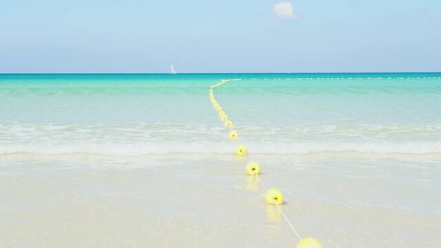 Yellow marker swim area buoys on sea. Yellow floating buoy over ocean.