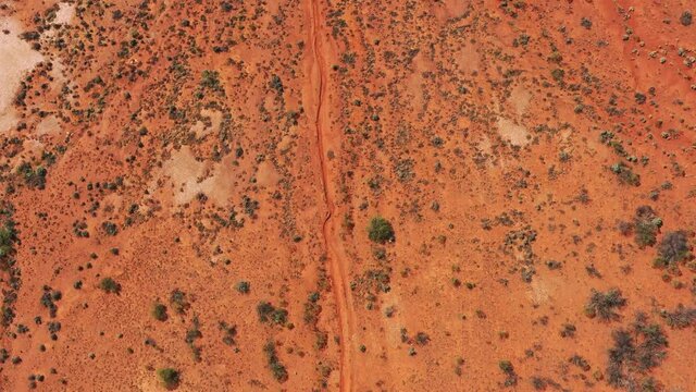 From Red soil of Australian outback desert up to blue sky horizon – aerial 4k
