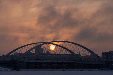 Fototapeta na wymiar Sunset over the bridge across Ishim river in Nur-Sultan, Kazakhstan.