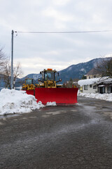 In winter, a huge bulldozer is parked for snow removal.
