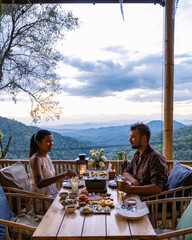 dinner in the mountains of Chiang Mai Thailand, table bbq, couple man and woman using kitchen tongs...