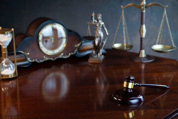 The law concept background.  Gavel of  the judge, Themis statue, the clock and the scale on the gray background.