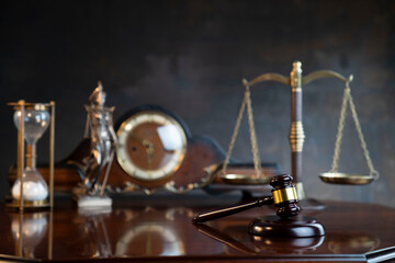 The law concept background.  Gavel of  the judge, Themis statue, the clock and the scale on the gray background.