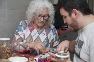Mature mother and adult son preparing some sweets together.