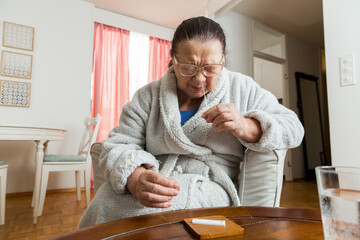 Senior woman taking Rapid Antigen test for self-diagnostic SARS-CoV-2, Covid-19, Coronavirus at home. 