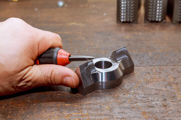 Burr removal tool for metal, wood, aluminum, copper and plastic. The worker removes burrs from the...