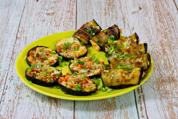 A festive snack of baked eggplant on a beautiful plate. Slices and rolls of vegetables with tasty filling. close up