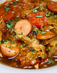 Traditional German meal close up with sausage, chicken, sauerkraut with parsley, in a broth soup