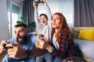 Happy family playing video games at home and having fun together.