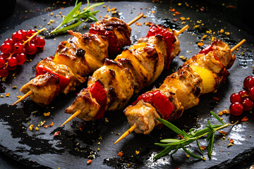 Chicken skewers - grilled meat with fresh vegetables on wooden background
