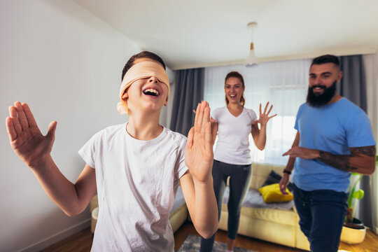 Family playing hide and seek at home, happy boy having fun with mom and dad.