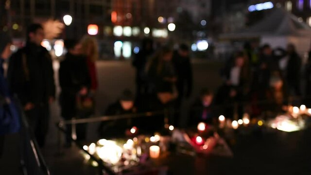 Front view of blur unrecognizable people Place Kleber main square with people lay down candles for victim's memory after a terrorist attack in the Strasbourg Christmas market area 