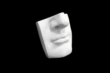 Fragment of plaster sculpture of a human face isolated on black background