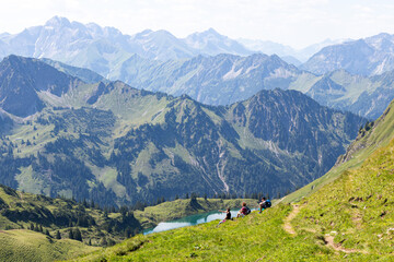 Fototapeta na wymiar Wanderer machen in den Alpen Bergen Pause und genießen die Landschaft 