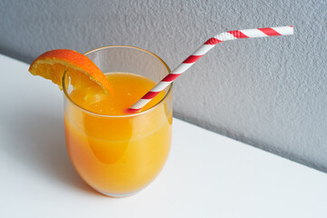 Top view of orange juice with a straw. Benefits of orange for health.