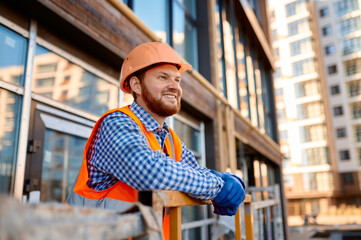 Portrait of smiling builder on hanging cradle